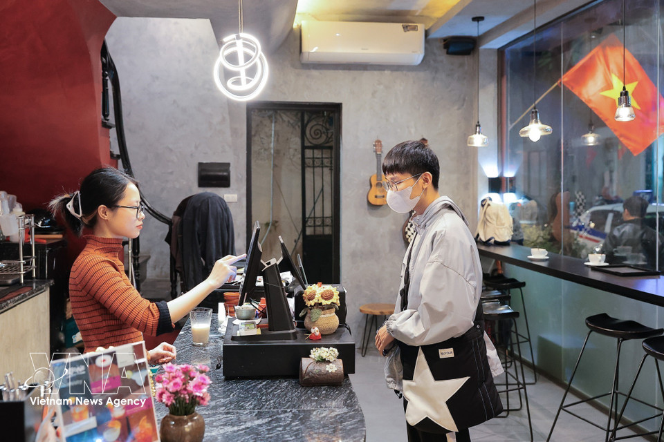 People make electronic payments when shopping, contributing to the growth of cashless consumption. (Photo: VNA)