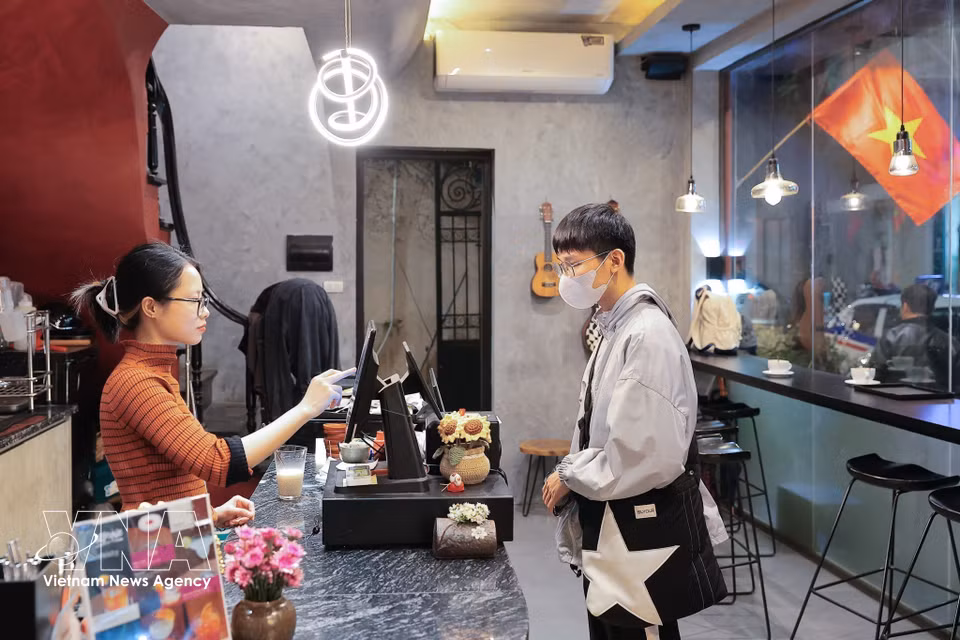 People make electronic payments when shopping, contributing to the growth of cashless consumption. (Photo: VNA)