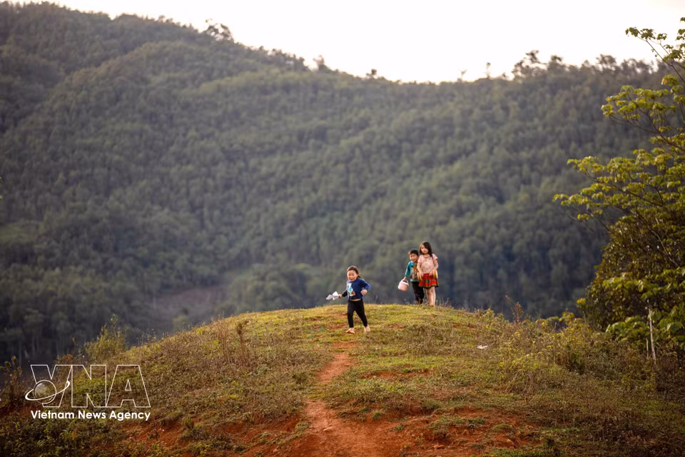 Children play along village paths amid the tranquil mountain scenery of Lang Sang village. (Photo: VNA)