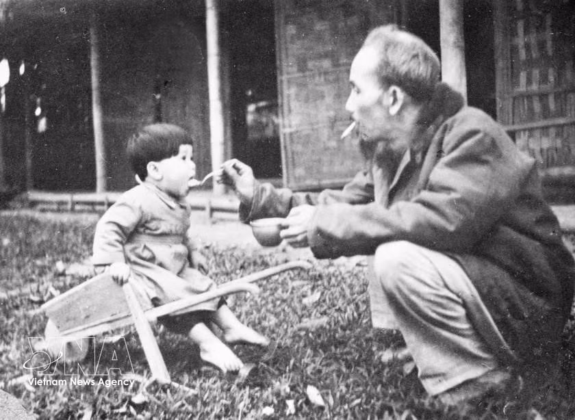 President Ho Chi Minh deeply loved children. Despite being extremely occupied, he always cared for children - the future generation of the country. In the photo: Ho Chi Minh feeds a child while visiting a children’s camp in the Viet Bac resistance base in 1950. (Photo: VNA archives)