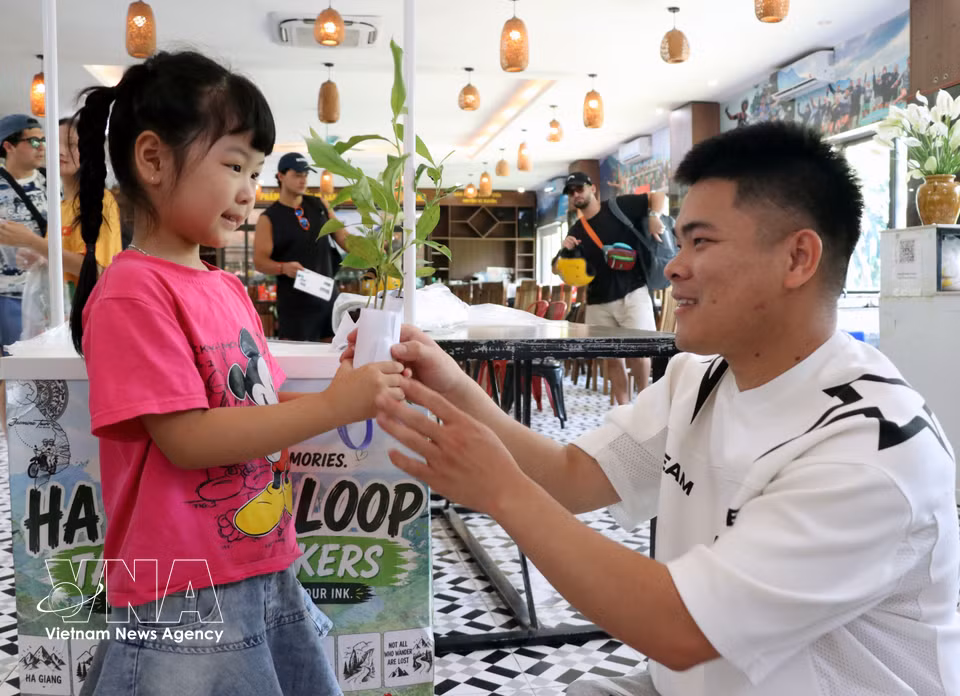 A visiting child receives a young tree for planting. (Photo: VNA)