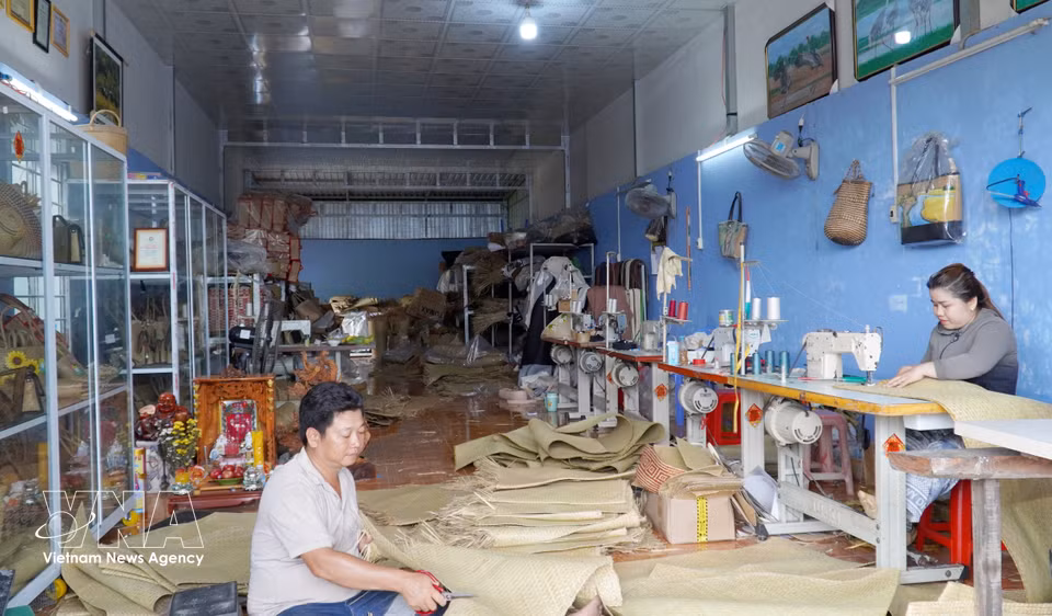 Residents in Giang Thanh border area are making handicraft from bulrush grass. (Photo: VNA)