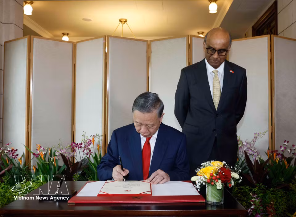 Party General Secretary and State President To Lam signs the guest book. (Photo: VNA)