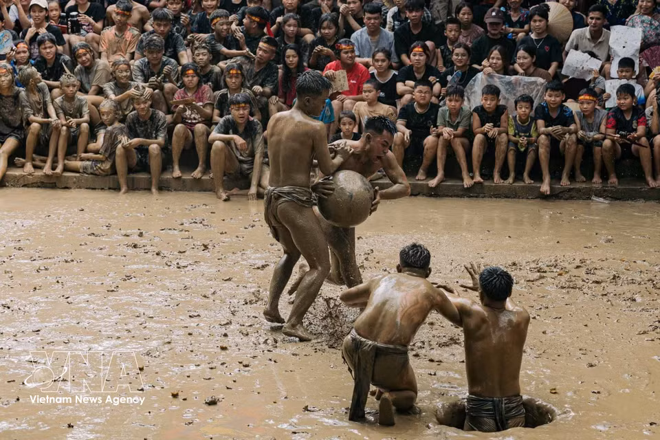 A player launches an attack, tightly clutching the wooden ball and attempting to break through the opposing team's defence to reach the scoring pit. (Photo: VNA)