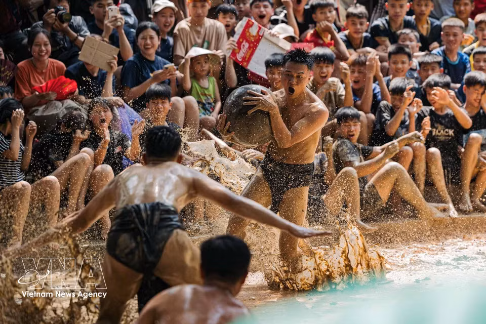 A player grips the wooden ball tightly and surges forward amid enthusiastic cheers from spectators lining the muddy arena. (Photo: VNA)