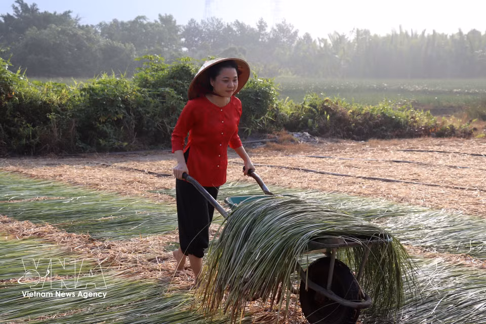 Nguyen Vu Cam Ngan, a resident of Hau Nghia commune, tries out traditional craft activities. (Photo: VNA)