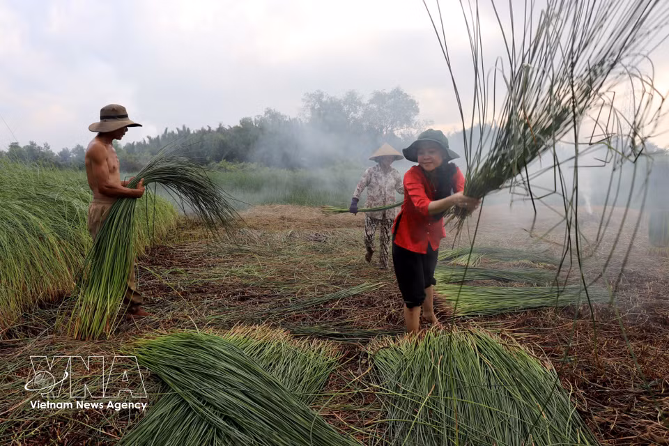Nguyen Vu Cam Ngan, a resident of Hau Nghia commune, tries out traditional craft activities. (Photo: VNA)