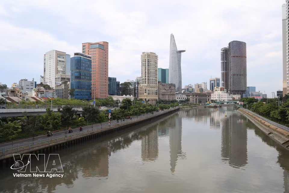 Clear water reflects Ho Chi Minh City's modern skyline on the Tau Hu - Ben Nghe Canal, seen from Calmette Bridge. (Photo: VNA)