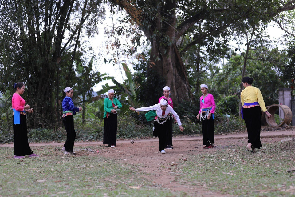 Players wind a string around the spinning top and pull it sharply to set it spinning on the ground. (Photo: VNA)
