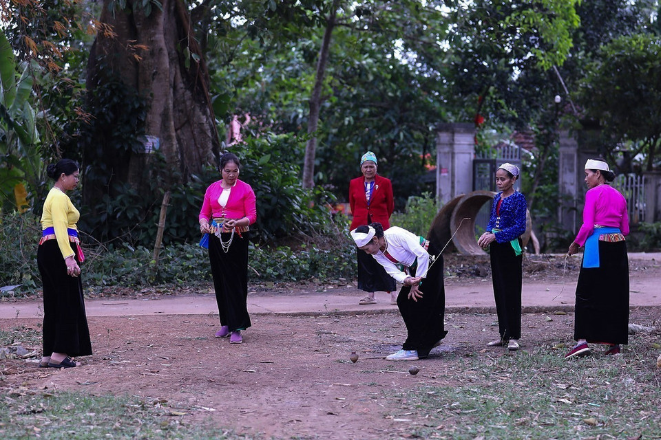 After launching the spinning top, players from each team throw their tops forcefully to hit those of the opposing team, aiming to stop them from spinning. (Photo: VNA)