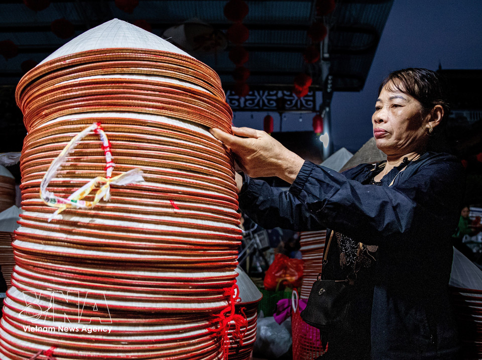 As the market ends, wholesale buyers gather to count and sort the hats they have purchased. (Photo: VNA)