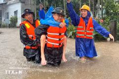 Military forces take a resident from a flooded area. Photo: VNA