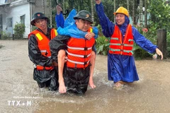 Military forces take a resident from a flooded area. Photo: VNA