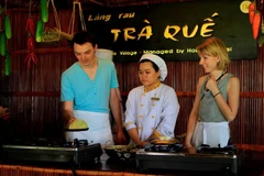 Foreign tourists experience making Xeo pancakes in Hoi An. Photo: VietnamPlus