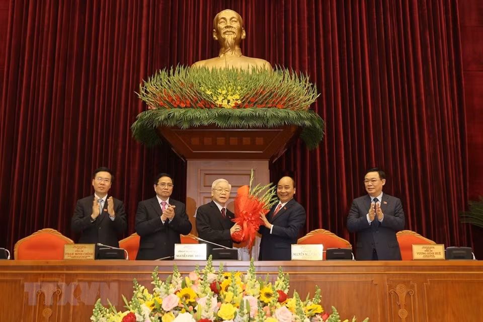 Prime Minister Nguyen Xuan Phuc, on behalf of the Politburo, presents flowers to congratulate Party General Secretary and State President Nguyen Phu Trong. (Photo: VNA)
