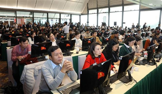 Reporters of local news agencies work at the press centre of the 13th National Party Congress (Photo: VNA)