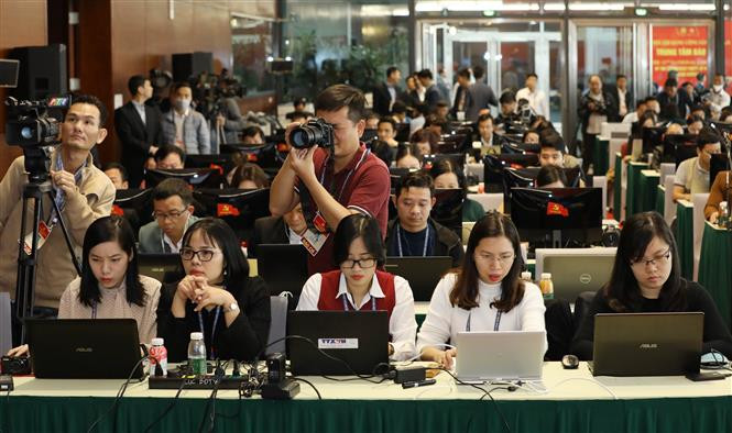 Reporters of local news agencies work at the press centre of the 13th National Party Congress (Photo: VNA)
