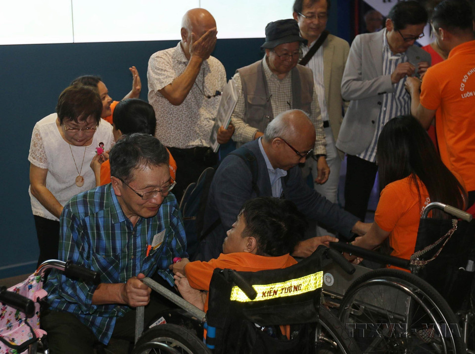 Child AO victims at Peace Village present gifts to Japanese delegates who attended a photo exhibition on war victims in Japan and Vietnam. (Photo: VNA)