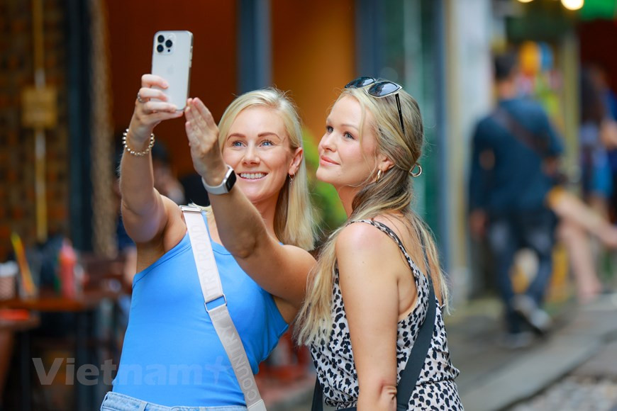 Female tourists freely take photos on the streets of Hanoi without fear for their safety. (Photo: Vietnam+)
