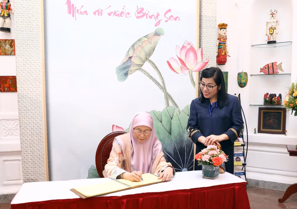YB Dato' Seri Dr. Wan Azizah Binti Wan Ismail writes in the guest book at the theatre. (Photo: VNA)
