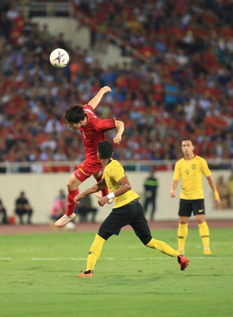 Midfielder Luong Xuan Truong (in red) vies for the ball with a Malaysian player (Photo: VNA)