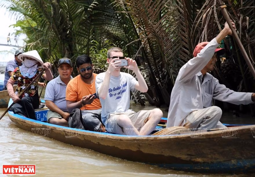 Foreign tourists explore the islet on small boats (Photo: VNA)