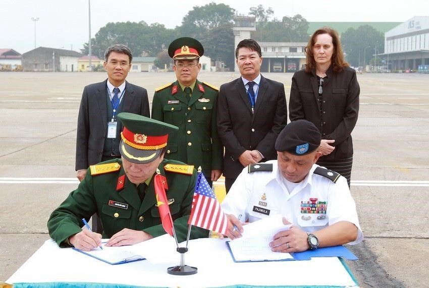 Representative of the Vietnamese Office For Seeking Missing Persons (VNOSMP) and representative of the US POW/MIA Accounting Agency (DPAA) sign a record of handing over 4 sets of remains of US soldiers during the 129th search, December 13, 2017, at Noi Bai International Airport (Hanoi) (Photo: VNA)