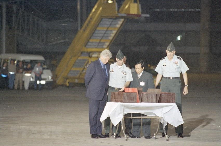 US President Bill Clinton attends a ceremony to receive the remains of three US soldiers handed over by the Vietnamese missing people searching committee at Noi Bai International Airport (Hanoi) November 18, 2000, during his official visit to Vietnam (Photo: VNA)