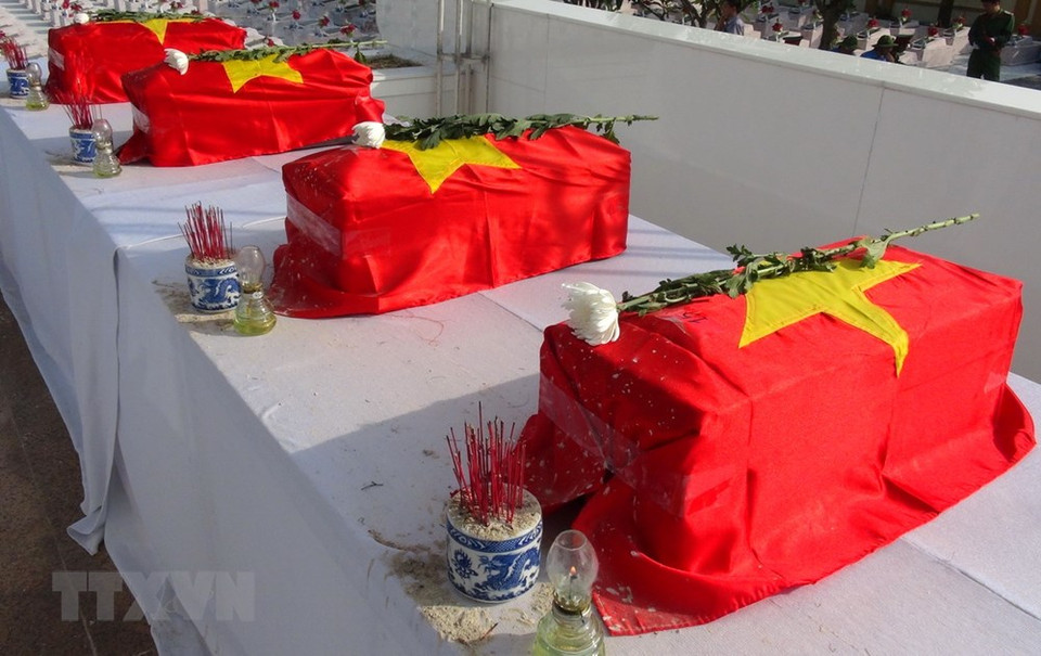 The coffins are draped with the national flag to honour the martyrs. (Photo: VNA)