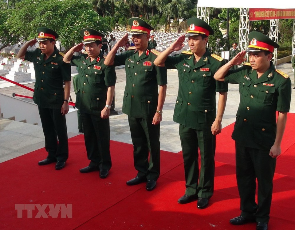 Army personnel salute to pay their last respect to the Vietnamese voluntary soldiers and experts who died on duty in Laos. (Photo: VNA)