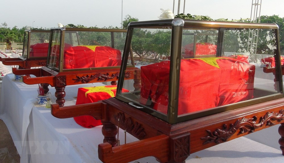 The coffins are draped with the national flag to honour the martyrs. (Photo: VNA)