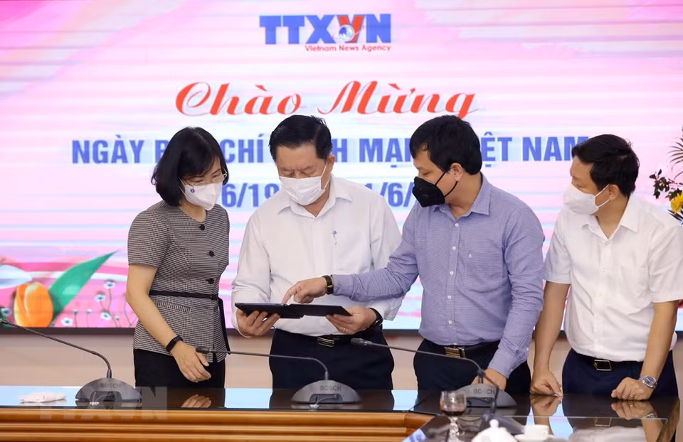 Vietnam News Agency Deputy General Director Vu Viet Trang introduces the news agency’s electronic publications to Secretary of the Party Central Committee and Chairman of its Commission for Information and Education Nguyen Trong Nghia. (Photo: VNA)