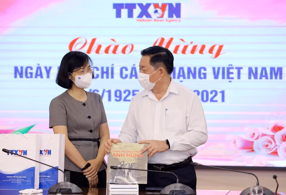 Vietnam News Agency Deputy General Director Vu Viet Trang presents a book published by the new agency to Secretary of the Party Central Committee and Chairman of its Commission for Information and Education Nguyen Trong Nghia. (Photo: VNA)