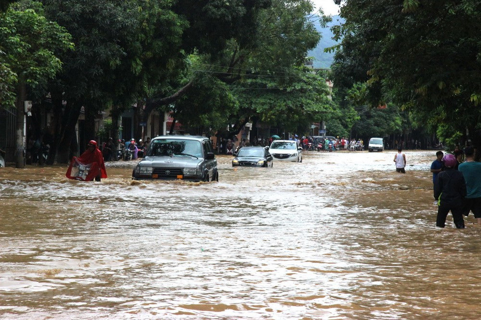 Vehicles are struggling to move along a flooded street in Ha Giang city, the capital of Ha Giang province. (Photo: VNA)