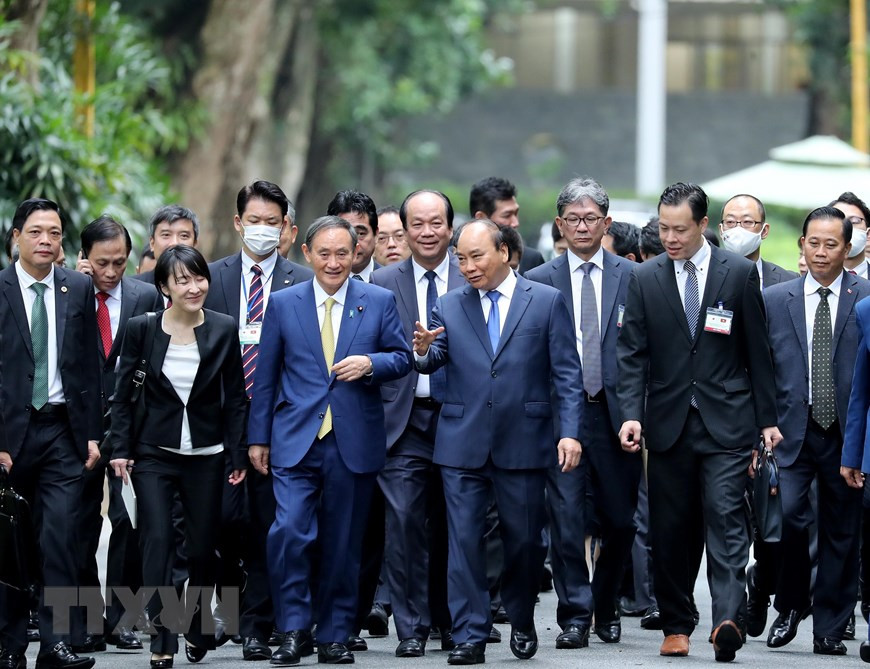 Japanese Prime Minister Suga Yoshihide and Prime Minister Nguyen Xuan Phuc have a walk in President Ho Chi Minh Relic Site (Photo: VNA)