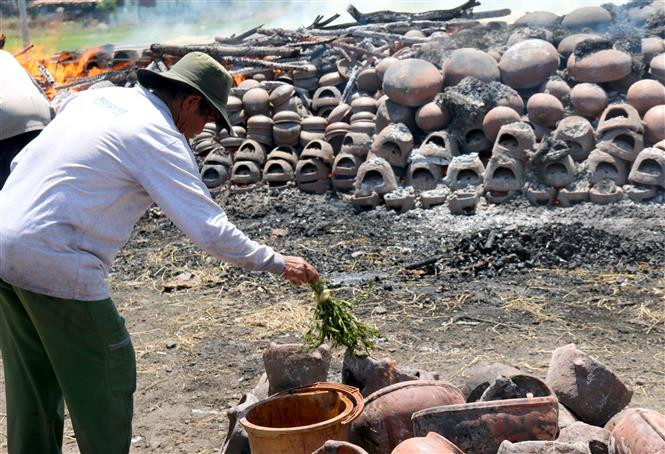 To create special patterns on new pottery products, the craftsmen sprinkle a special liquid on the surface which is made from sandbox fruit and golden-apple fruit (Photo:VNA)