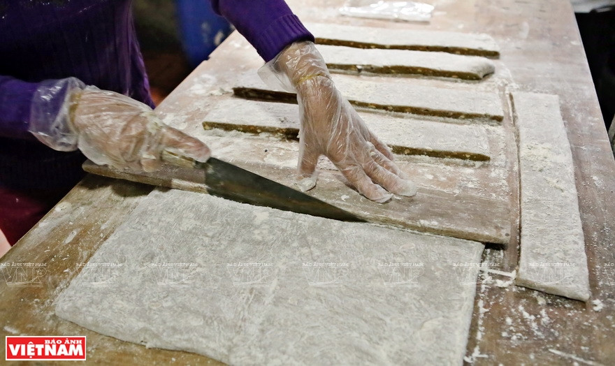 After the flattened dough is completely cooled, they are cut into rectangular sheets (Photo: VNA)