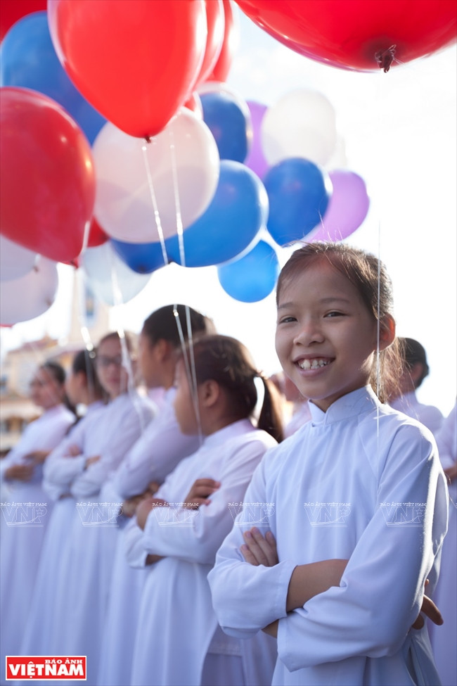 A girl in white traditional robe join the crowd in celebration of the festival 'Dai Le Via Duc Chi Ton'. (Photo: VNA)