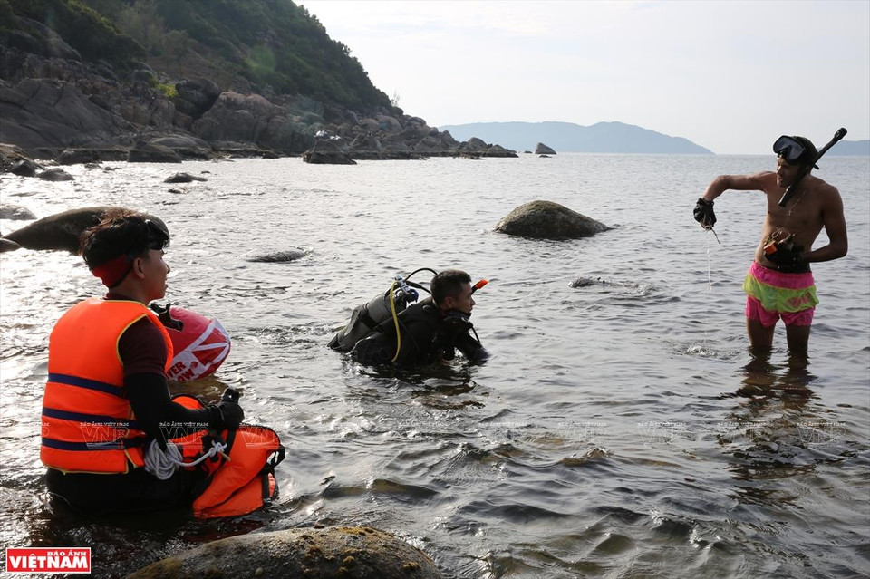 Certified scuba-divers also join the group in cleaning Da Den beach (Photo: VNA)