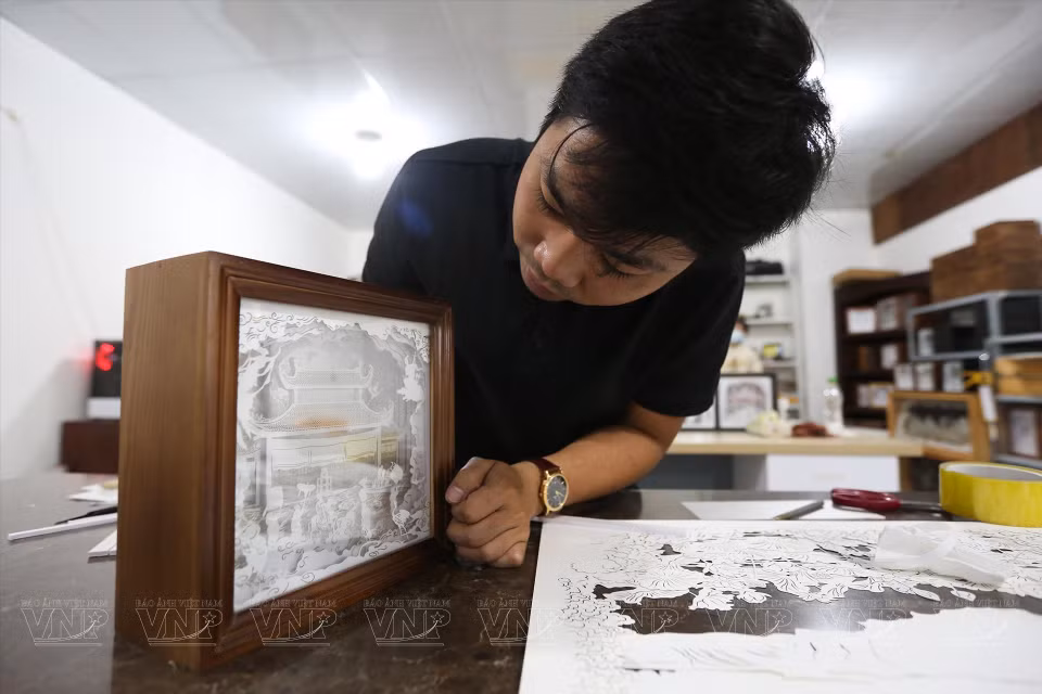Duy said that creating a paper lamp involves at least five stages: brainstorming design ideas; separating paper layers; dividing the initial sketch into layers of front and back, and light and dark; cutting and engraving; and assembling and reinforcing the frame. (Photo: VNA)