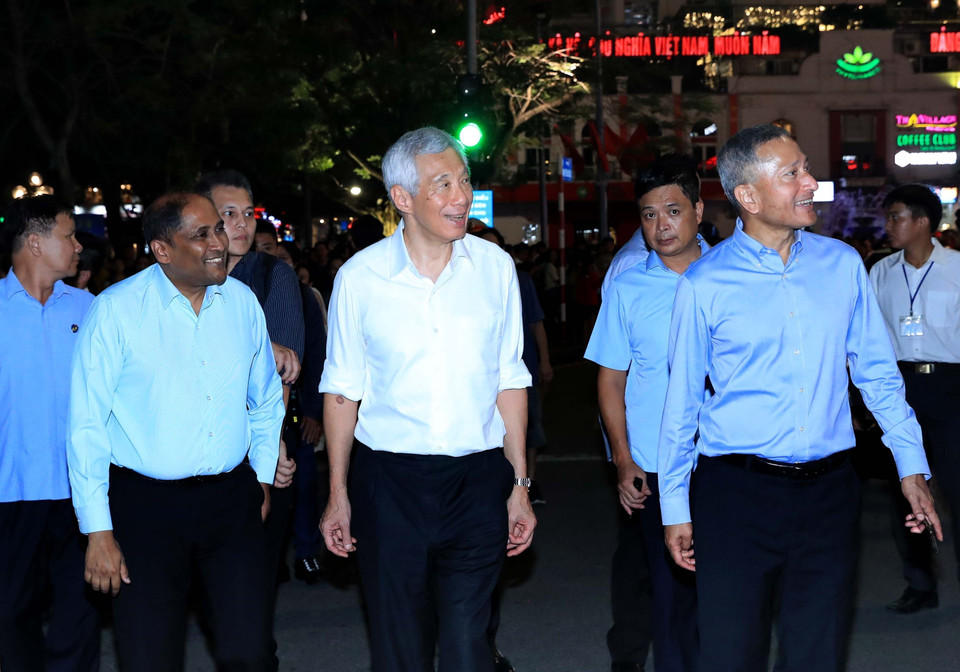 The Singaporean Prime Minister and his entourage take a stroll around Hoan Kiem Lake. (Photo: VNA)