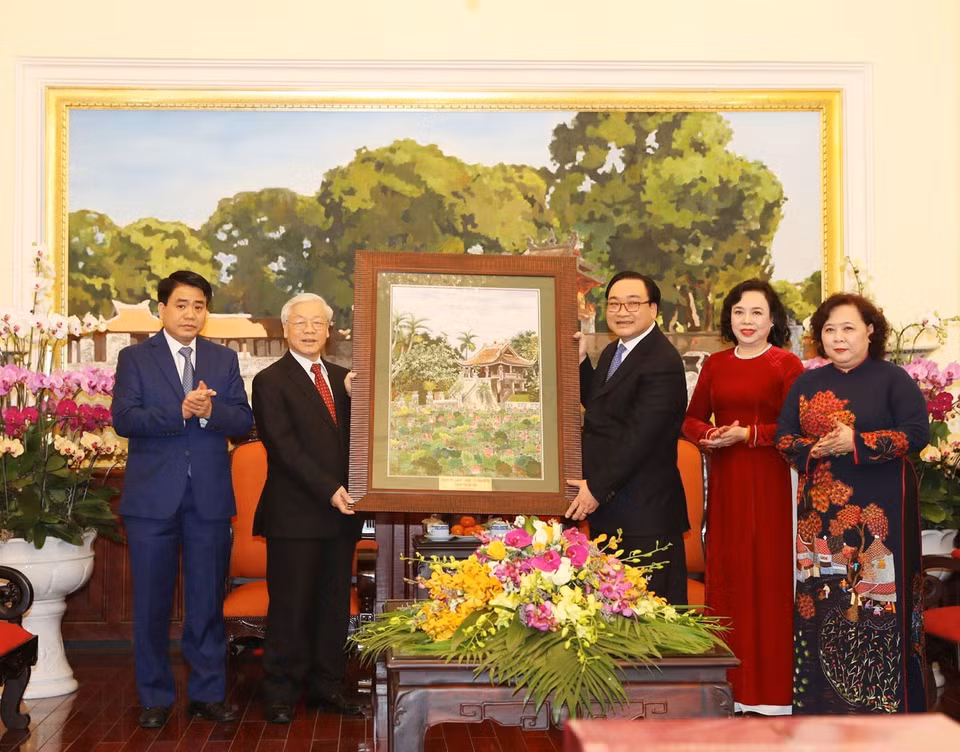 The Party leader presents a painting as a gift to Hanoi authorities (Photo: VNA)