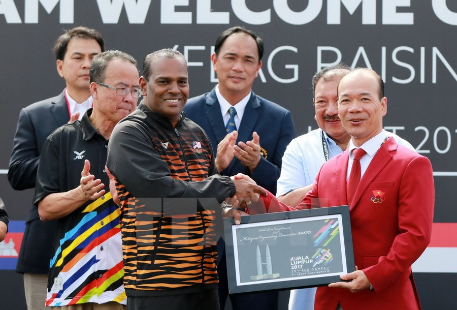 A representative of the 29th SEA Games organising board (L) presents a gift to the Vietnamese delegation (Photo: VNA)