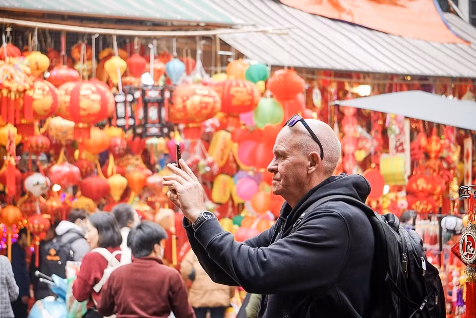 International tourists choose to linger and soak in the pre-Tet ambiance at Hang Luoc Flower Market. (Photo: VNA)