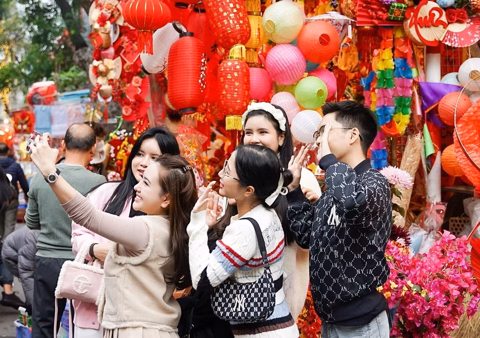 The traditional Tet flower market on Hang Luoc street in the Hanoi’s Old Quarter continues to attract a significant number of young people, offering them an opportunity to celebrate the Lunar New Year and capture the essence of the early moments of the year. (Photo: VNA)