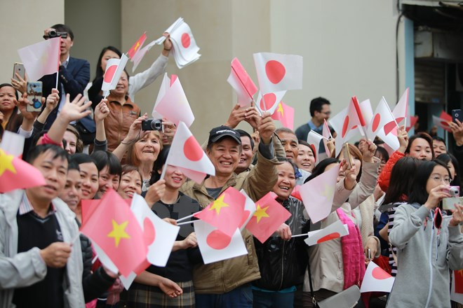 People carying Vietnamese and Japanese national flags wait outside the Temple of Literature. (Source: VNA)