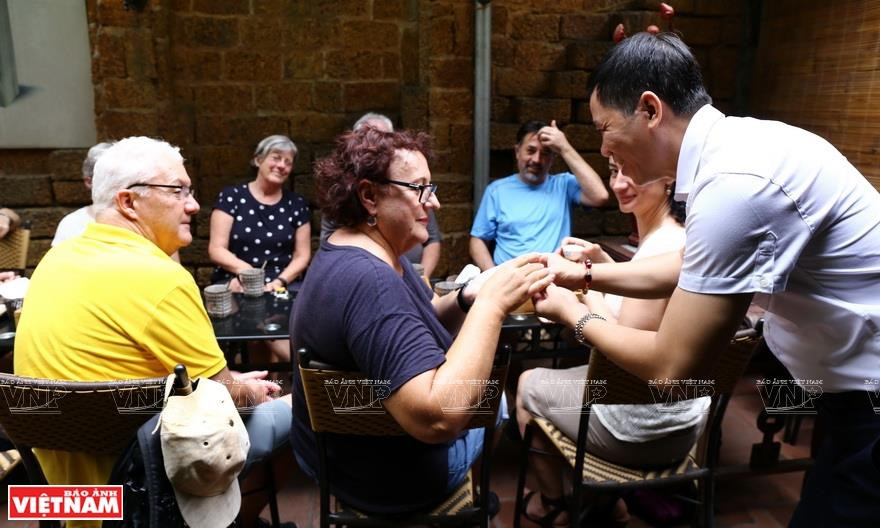 Tea-making artisan Hoang Anh Suong invites visitors to enjoy Truong Xuan’s tea (Photo:VNP/VNA)