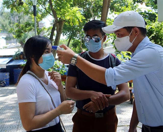 Measuring tourists' body temperature before entering Ngu Hanh Son (Marble Mountain) tourism site. (Photo: VNA)