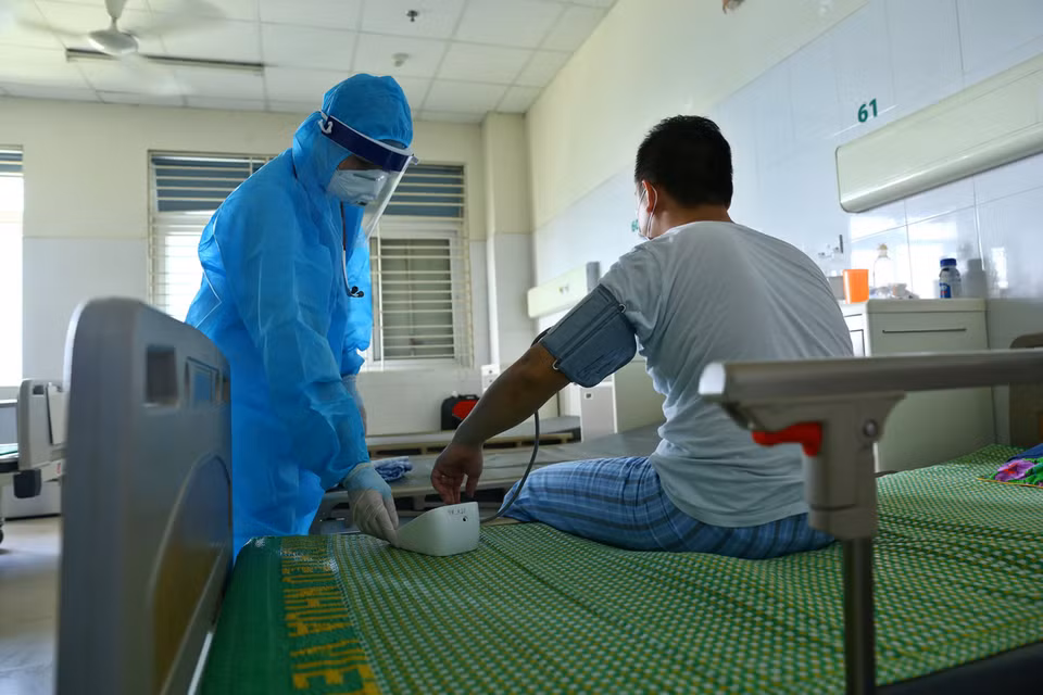 A doctor checks the health of a COVID-19 patient being treated at the National Hospital for Tropical Diseases, No.2, Dong Anh district, Hanoi (Photo: VNA)