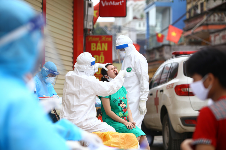 Health staff take samples for testing for people in Ha Loi village (Me Linh commune, Me Linh district, Hanoi), where more than 10,000 people are isolated as soon as there is a suspected COVID-19 infected case. Thanks to the swift quarantine measures, Vietnamese localities have been successful controlling the epidemic. (Photo: VNA).